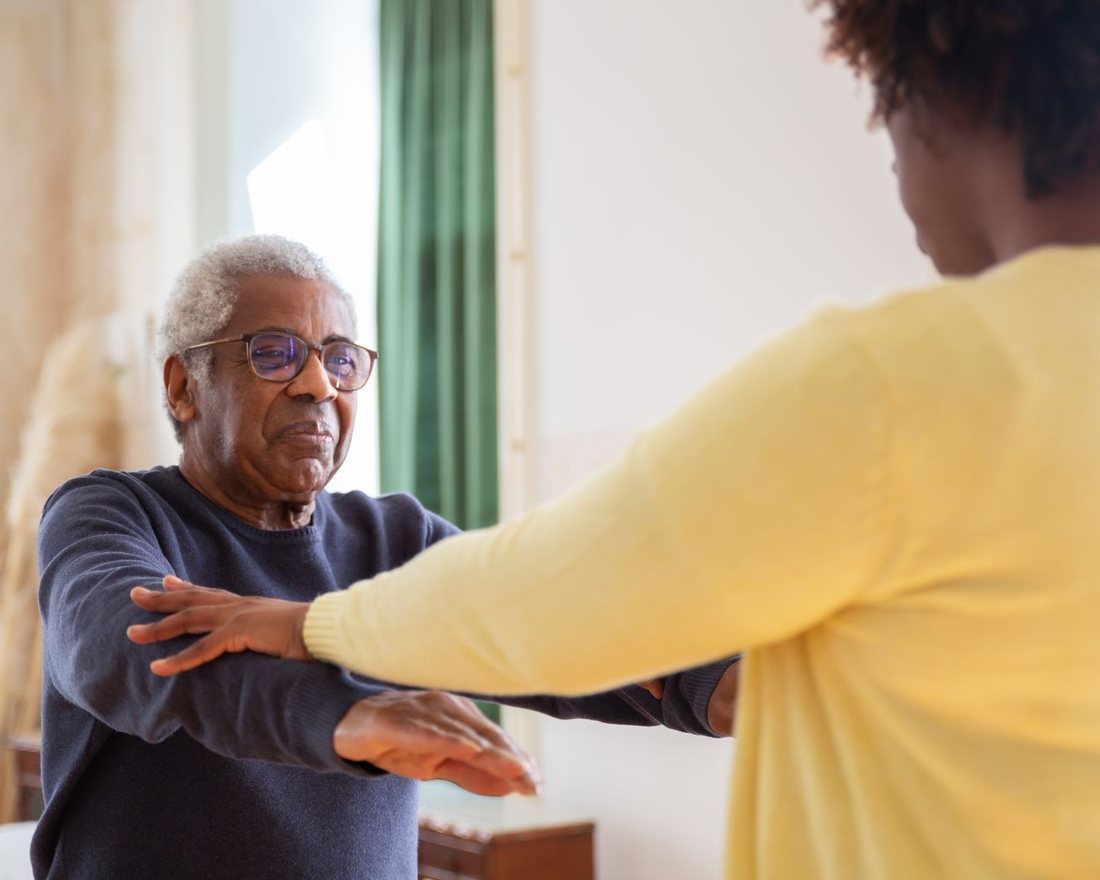 A caregiver warmly assisting a senior resident